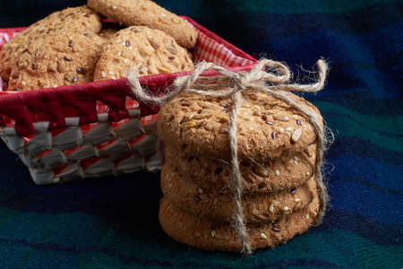 Savory cookies sprinkled with sesame seeds, sunflower on a wooden table and burlap background