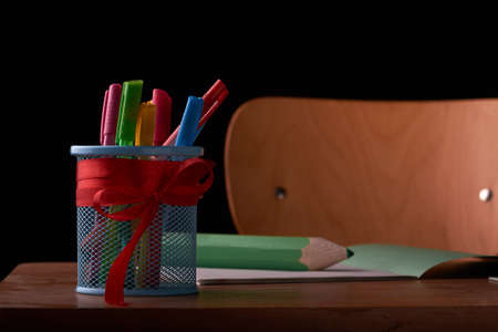 back to school concept and holder for pens on school desk isolated