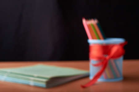 Blurred Many pencils in the metal holder on wooden table on black backgroundの写真素材