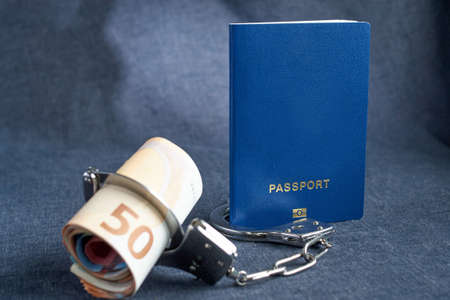 Blank blue passport background on gray background with from the euro in handcuffs. the concept lack of money for travel, povertyの写真素材