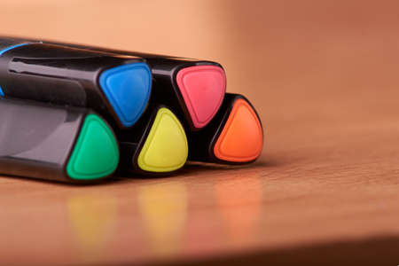 colored markers on the school table on wooden background