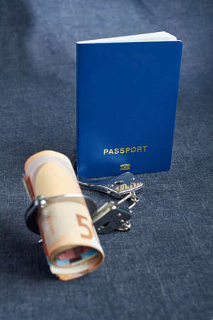 International blank of a biometric passport with money in handcuffs
