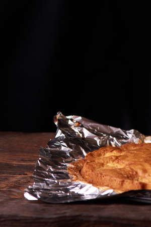Apricot baked in foil on a wooden tableの写真素材