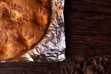 Apricot baked in foil on a wooden table