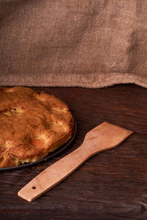 apricot cake with a wooden shovel on wooden backgroundの写真素材