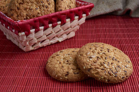 Cookies with sesame and sunflower seeds on wooden table and burlap background. Healthy eating