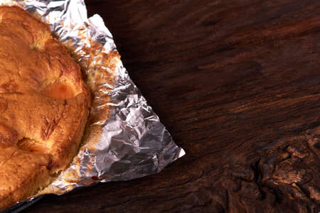 Apricot baked in foil on a wooden tableの写真素材