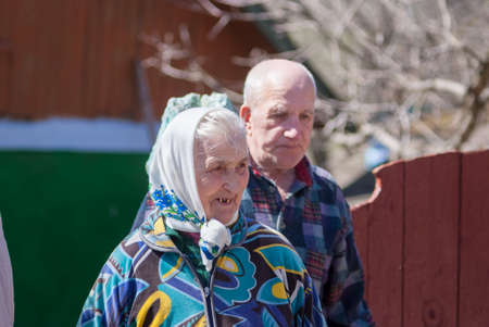Ukraine, kamyanets-podilsky - APRIL 11, 2018: Unidentified old man and woman talking in fron of their house. Ukraine rural environment.のeditorial素材