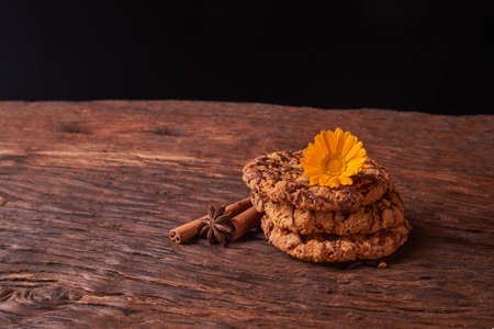 Closeup on stack of chocolate Chip ion wood background with live flowers - cookies for mom on...