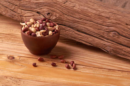 dry peanuts background. close up dry peanuts in clay bowl.
