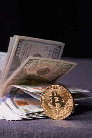 Golden metal bitcoin on dollar bills background. a lot of money in cash. 100 dollars texture. dear...