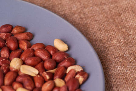 fried peanuts on blue plate on sackcloth
