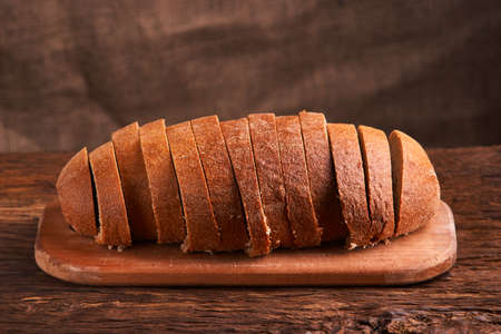 Sliced bread on a wooden table and on a black background