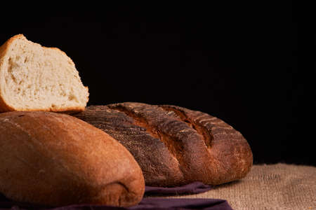 Different bread and wheat on the rustic table. Selective focus