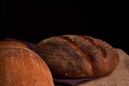 Different bread and wheat on the rustic table. Selective focus
