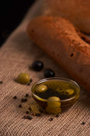 Fresh Italian baguette on wooden table with oil.Selective focus
