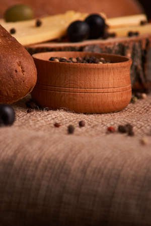 Peppercorns in a wooden bowl on table with food rustic styleの写真素材