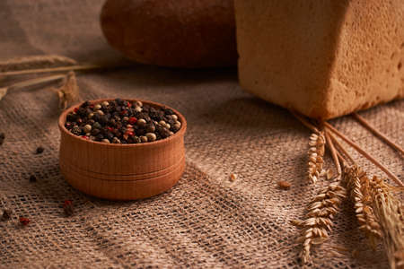 Peppercorns in a wooden bowl on table with food rustic style
