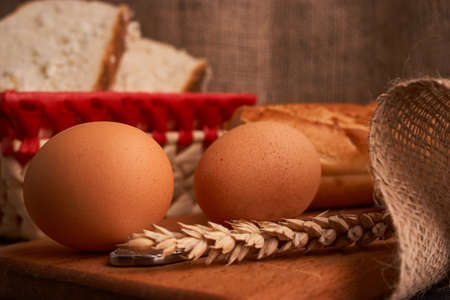 eggs, bread and milk glass on wooden table and dark wooden backgroundの写真素材
