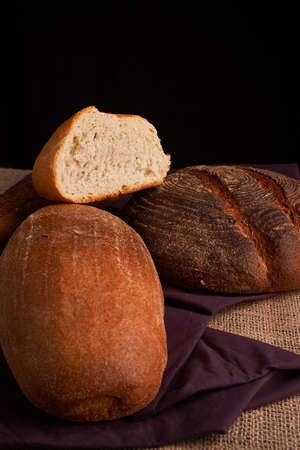 Bakery - gold rustic crusty loaves of bread and buns on black chalkboard background