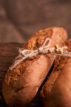 Two Fresh baguettes on dark wooden table