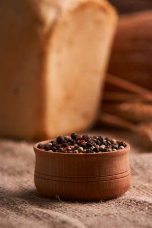 Peppercorns in a wooden bowl on table with food rustic styleの写真素材