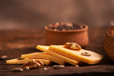 Peppercorns in a wooden bowl on table with cheese.