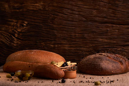 Bakery - gold rustic crusty loaves of bread and buns on black chalkboard backgroundの写真素材