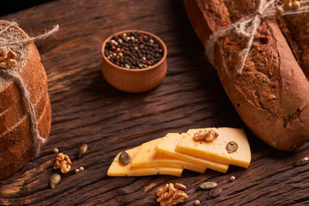 Peppercorns in a wooden bowl on table with cheese.