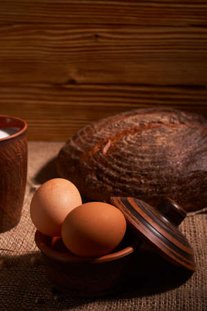 Eggs with bread and kitchen utensils on vintage wooden backgroundの写真素材