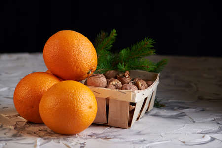 nuts on the wooden basket and oranges on white background. healthy new year s breakfast.の写真素材