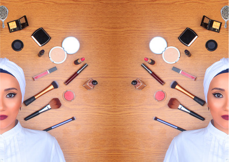 Woman in full makeup wearing turban lying on floor surrounded by makeup / Woman in full makeupの写真素材