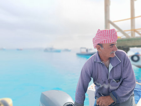 Old Sailor in the Sea Riding and Sailing with his Boat An old sailor with a white with a white...