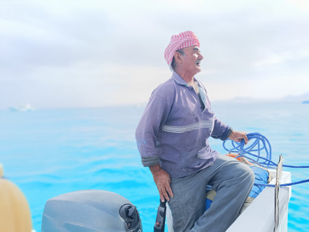 Old Sailor in the Sea Riding and Sailing with his Boat An old sailor with a white with a white...
