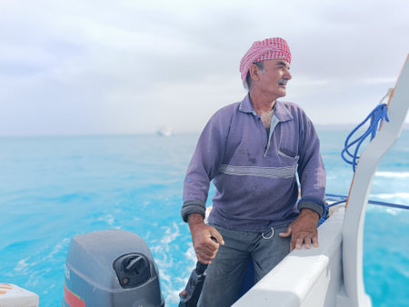 Old Sailor in the Sea Riding and Sailing with his Boat An old sailor with a white with a white...