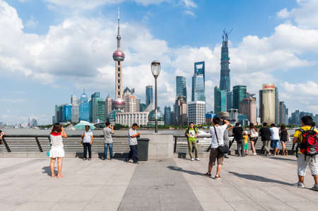 SHANGHAI-SEP 19. Cheerful group Chinese at The Bund. It is a waterfront area, central Shanghai, which runs along the western bank of Huangpu River, facing Pudong skyscrapers. Shanghai, Sep 19, 2013.のeditorial素材