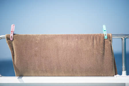 a towel hanging on boat rail under sunshineの写真素材