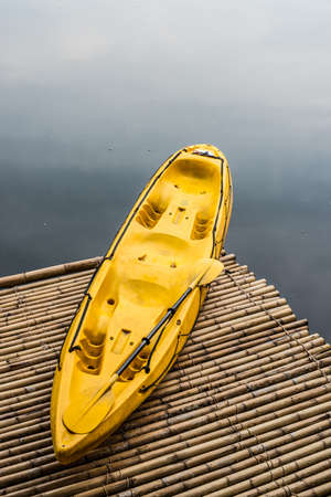 yellow kayak on bamboo raft in lakeの写真素材