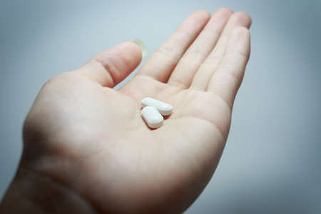 drug two tablets on handの写真素材