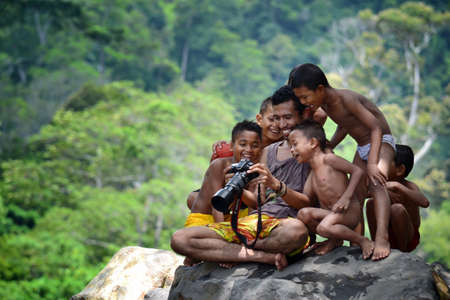 a photographer reveals her work to children on the riverbankのeditorial素材