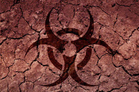 A biohazard symbol on cracked soil. An ecological concept.の写真素材