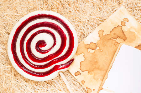 A retro looking photo of lollipop on a straw background with place for your text.の写真素材