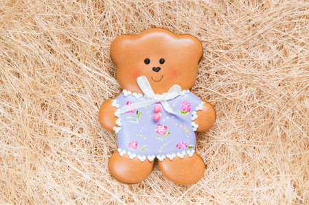 A straw background with a handmade honey-cake bear for a baby shower party, a birthday party or other events.の写真素材
