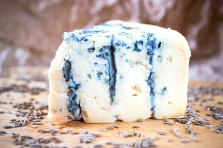 A piece of an amazing fresh blue cheese on a wood board.の写真素材