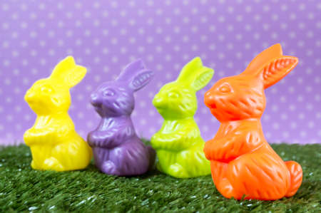 Lots of colorful Easter bunnies on the artificial grass.の写真素材