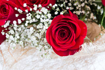 A bouquet of beautiful red roses with tiny white flowersの写真素材