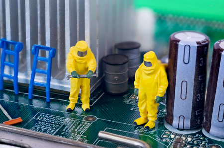 Two toy technicians are repairing, cleaning and diagnosing a motherboard.の写真素材