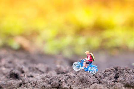 A toy cyclist is taking a ride in the sunset or the sunrise. Ecotourism concept.の写真素材