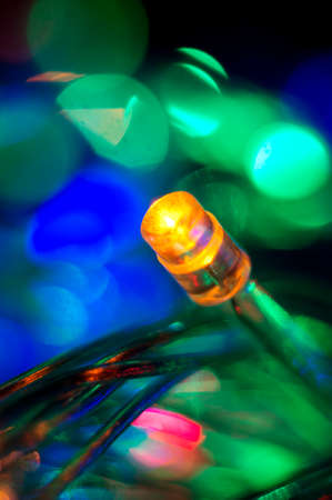 A colorful background with glowing Christmas garland. Macro shot. Selective focus.