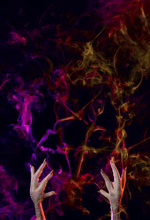 Conceptual photo of pentagram, made of smoke and hands of a necromancer trying to call the devil. Halloween or religious concept.の写真素材